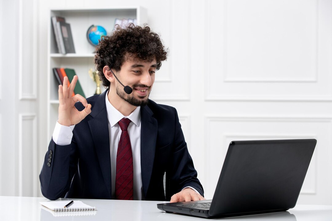 customer-service-handsome-young-guy-office-suit-with-laptop-headset-showing-ok-gesture_140725-164847